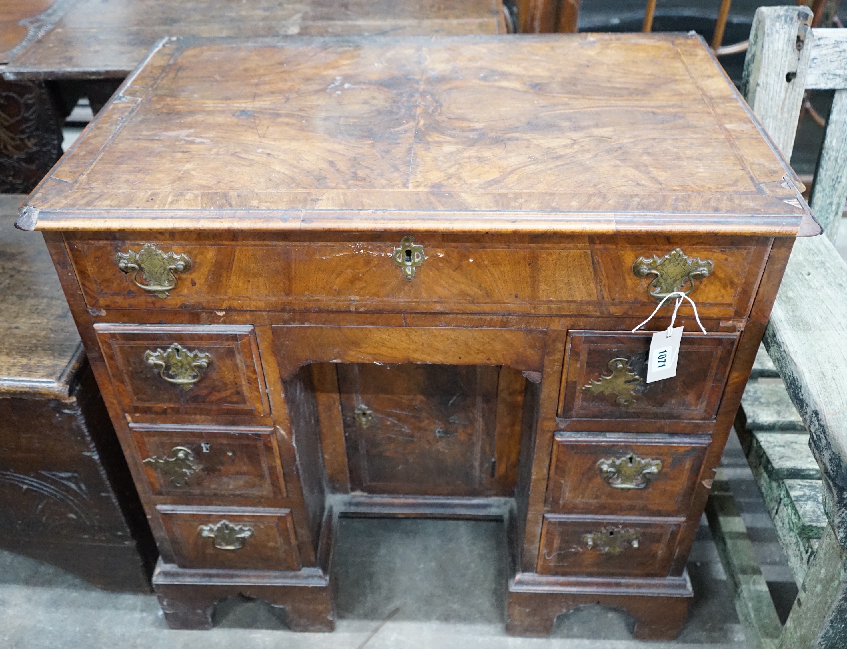 An 18th century feather banded walnut kneehole desk, width 81cms, depth 52cms, height 76cms.